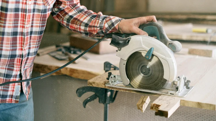 A worker was using a circular saw to cut wood without properly securing the workpiece.